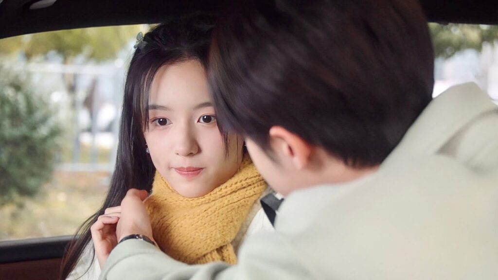 يساعدها بإرتداء الوشاح فتحمر خجلاً و يوصلها الى المنزل ( احبني و احب صوتي )