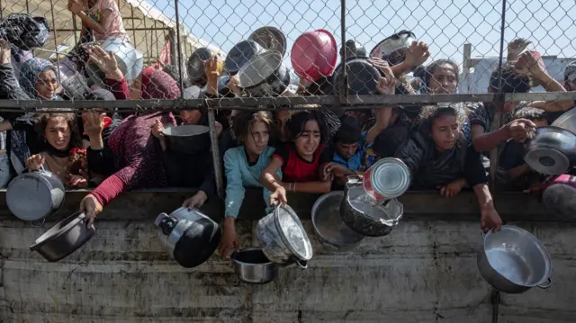 صورة لأطفال فلسطينيين في قطاع غزة يحتشدون أملاً في الحصول على وجبة من الطعام.