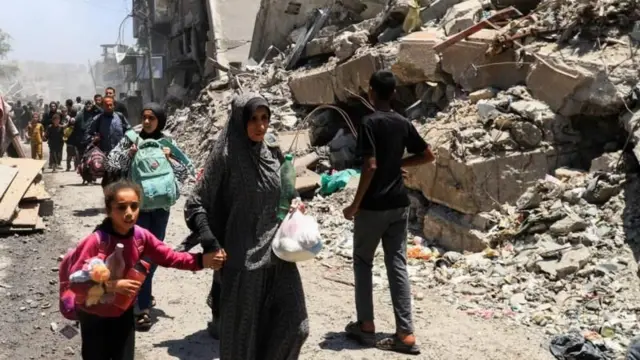 امرأة فلسطينية تمشي وسط الركام في غزة 