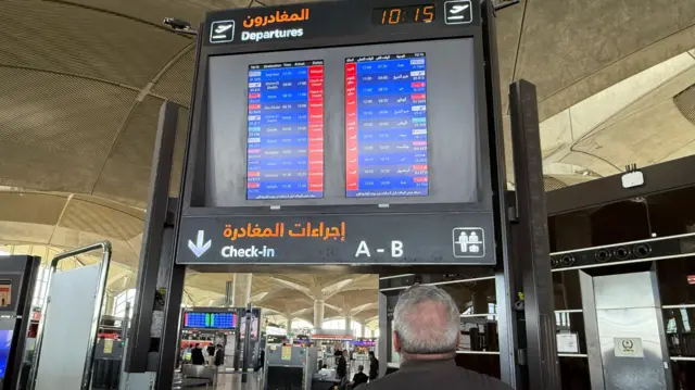 شاشة تعرض معلومات عن رحلات جوية متأخرة وملغاة في مطار الملكة علياء الدولي في عمّان