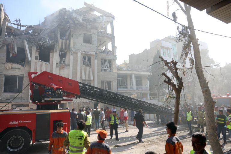 epa12172797 Fire fighters, rescue workers and security personnel work around a building that was hit by Israeli air strikes in central Tehran, Iran, 13 June 2025. Israel confirms it has launched strikes on Iran's 'nuclear program' as blasts are heard across the country. The strikes are part of Operation Rising Lion, Israel's Prime Minister Benjamin Netanyahu said, adding Iran was a threat to "Israel's very survival". EPA-EFE/ABEDIN TAHERKENAREH