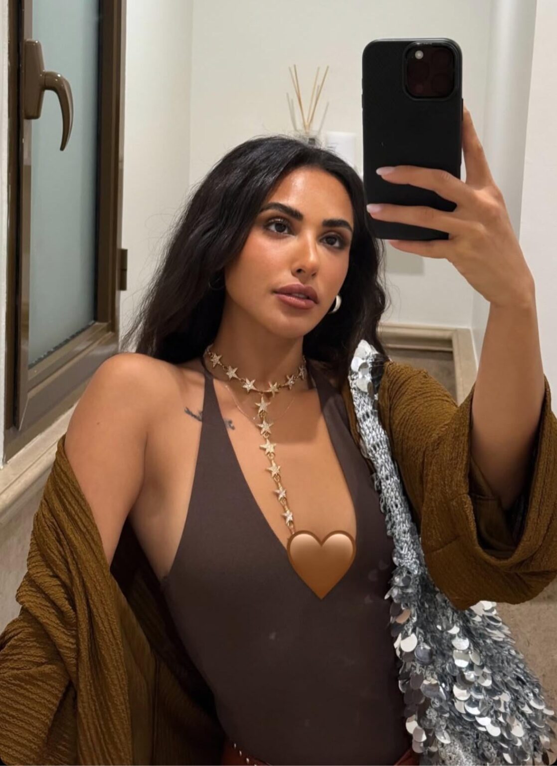 Aya teasing with a 🤎 on her boob