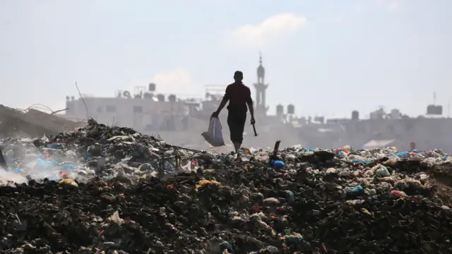 رجل فلسطيني في مكب نفايات القمامة في مخيم البريج وسط قطاع غزة في 7 يوليو/تموز 2025