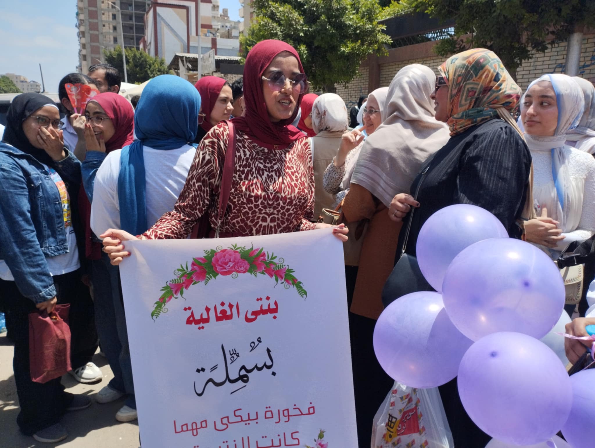 والدة طالبة ثانوية عامة تدعم ابنتها بلافته أمام مدرستها بالإسكندرية