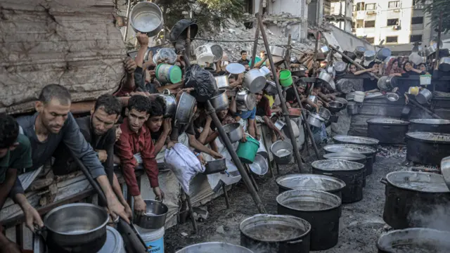 فلسطينيون، بينهم أطفال، ينتظرون في طوابير للحصول على وجبات ساخنة وسط حصار إسرائيلي وهجمات مستمرة في قطاع غزة