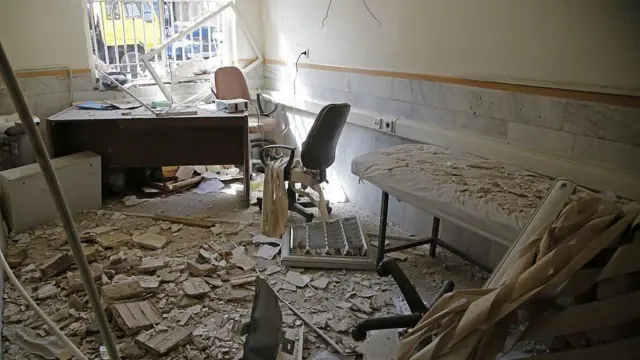 صورة لسجن إيفين في أعقاب غارات إسرائيلية على الموقع في يونيو/حزيران، تُظهِر سريراً مغطى بالحطام، وركاماً يغطي الأرضية، ونافذة ذات قضبان يتسلل منها الضوء، وأسلاكاً تتدلى من الجدران والسقف