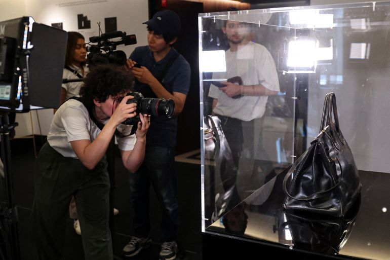 Journalists attend the presentation of the "Birkin" bag by Hermes which belonged to British-French actress and singer Jane Birkin at the Sotheby's auction house in Paris on July 2, 2025 and which will be auctioned by Sotheby's as part of the Fashion Icons auction sale.