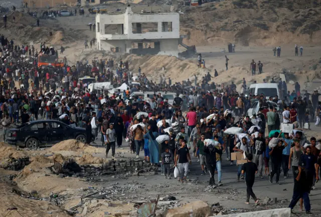 فلسطينيون في قطاع غزة يتجمعون لتلقي مساعدات في 22 يونيو/حزيران 2025
