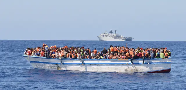 صورة أرشيفية لأكثر من 350 مهاجراً محشورين في قارب خشبي مكتظ للغاية كان موجوداً في المياه شمال ليبيا مباشرة في 28 مايو/أيار 2015.