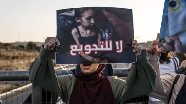 نظّم سكان أبو غوش مظاهرة تضامنية عند مدخل قريتهم احتجاجاً على هجمات إسرائيل على غزة، وقتل الصحفيين، وسياسة التجويع، في 22 أغسطس/آب 2025، بالقرب من القدس الشرقية. 