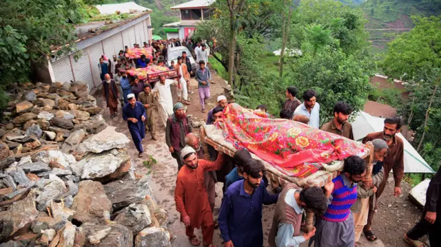 سكان يحملون نعوش ضحايا فيضانات ناجمة عن أمطار في مظفر آباد عاصمة الشطر الباكستاني من كشمير