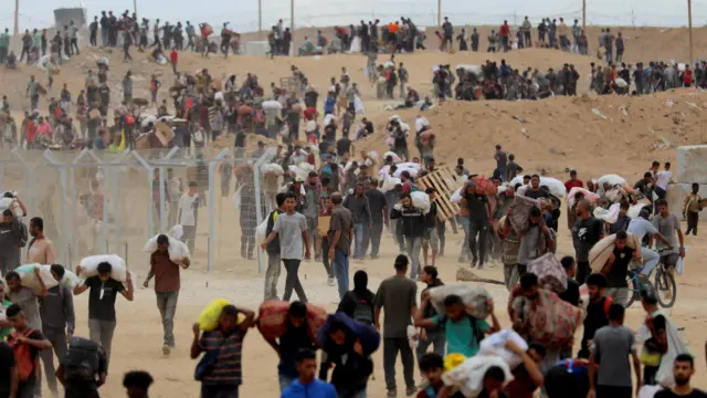 غزيون يحملون أكياس الطحين