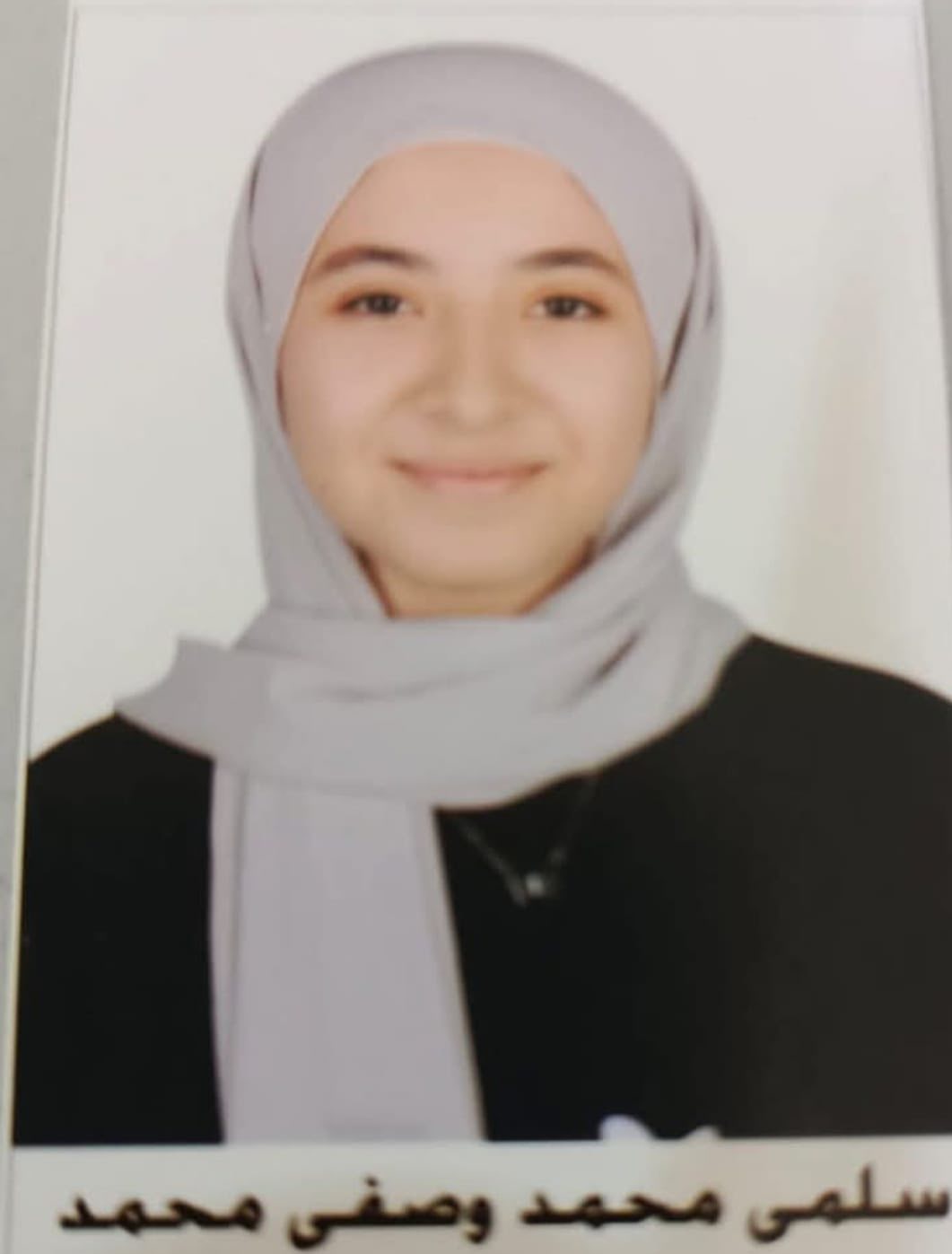 May be an image of ‎1 person, smiling, scarf and ‎text that says '‎سلمى محمد وصفى محمد‎'‎‎