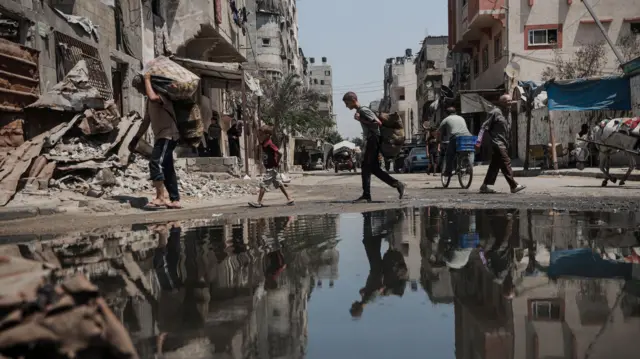 فر سكان المنطقة الفلسطينيون حاملين أمتعتهم التي استطاعوا حملها إلى مناطق اعتقدوا أنها آمنة، وذلك في أعقاب الهجمات التي شنها الجيش الإسرائيلي على شمال غزة، في 22 أغسطس/آب 2025. 