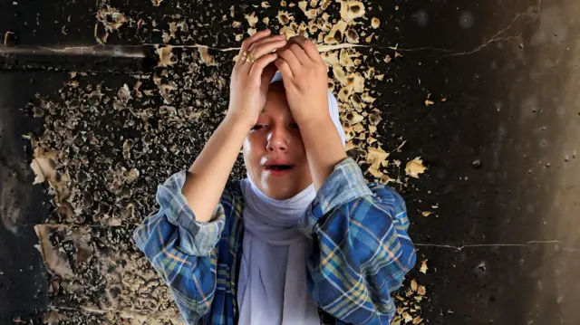 فلسطينية تبكي قرب موقع غارة إسرائيلية ليلية على مدرسة تابعة للأونروا كانت تؤوي النازحين، في خان يونس، جنوب قطاع غزة، في 3 آب/أغسطس 2025