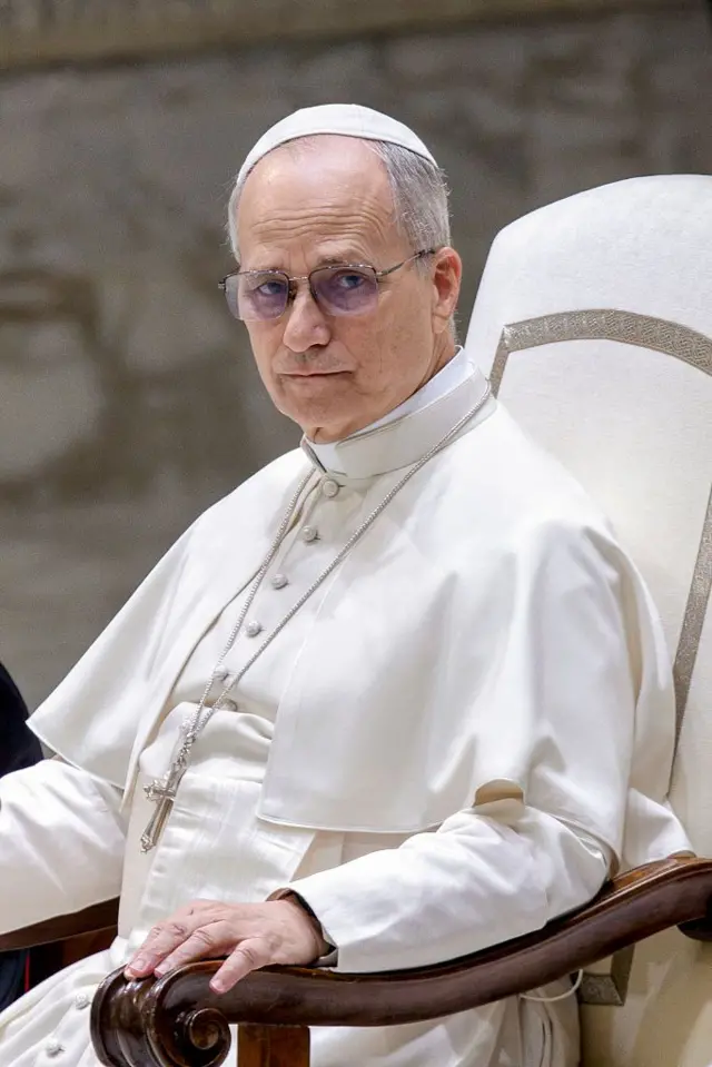 البابا ليون الرابع عشر خلال مقابلته العامة الأسبوعية في قاعة بولس السادس في الفاتيكان، مرتدياً الرداء الأبيض البابوي، ويتدلى من عنقه صليب.