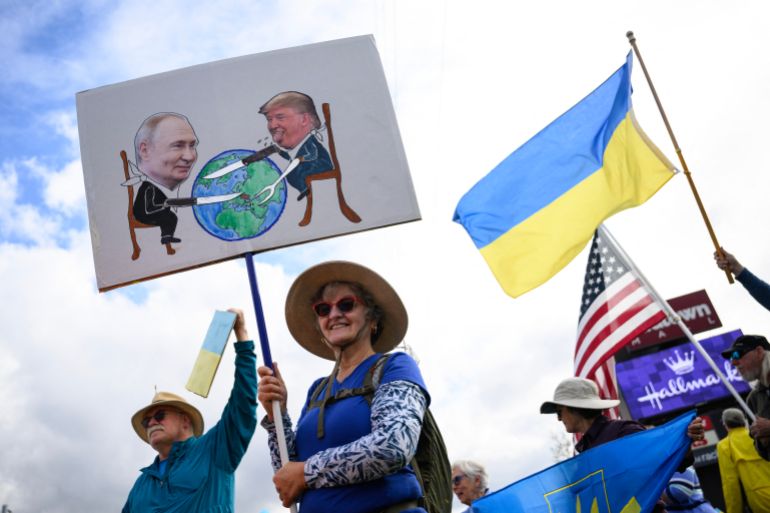 Demonstrators wave flags and hold signs as they rally in support of Ukraine along Seward Highway in Anchorage, Alaska, on August 14, 2025, on the eve of the scheduled meeting between the US and Russian presidents.