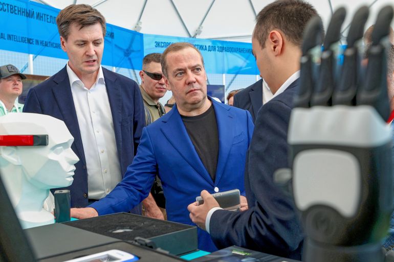 Russian Security Council Deputy Chairman and the head of the United Russia party Dmitry Medvedev, center, visits an exhibition during an opening of the Startup Village international technology conference at the Skolkovo Innovation Center in Moscow, Thursday, May 29, 2025. (Ekaterina Shtukina, Sputnik Pool Photo via AP)