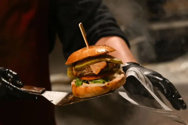 كشك يبيع البرغر في ساحة السوق المدرجة في قائمة اليونسكو في كراكوف، بولندا، يوم 29 نوفمبر 2024.
