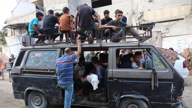 فلسطينيون ينقلون جثمانًا مُكفَّنًا، لشخص قُتل في غارة إسرائيلية، قبل تشييع جنازته في مستشفى الشفاء بمدينة غزة، في 21 أغسطس/آب 2025. 