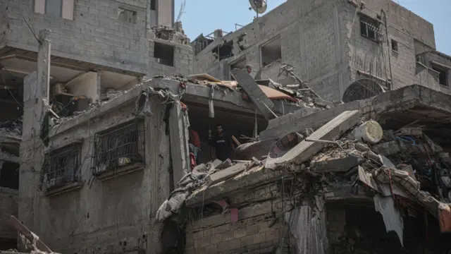 يتفقد سكانٌ الدمار الذي لحق بالمباني المنهارة في حيي الزيتون والصبرة بمدينة غزة، عقب الغارات العسكرية الإسرائيلية المتواصلة في 23 أغسطس/آب 2025.