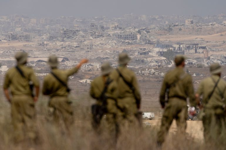 SOUTHERN ISRAEL, ISRAEL - AUGUST 13: Israeli soldiers look at destructed buildings in the Northern Gaza Strip as they are standing at a view point on the Israeli side of the border on August 13, 2025 in Southern Israel, Israel. Last week Israel's security cabinet approved Prime Minister Benjamin Netanyahu's proposal to expand IDF occupation of the Gaza Strip, including taking "complete control" of Gaza City. The planned offensive has been met with widespread condemnation by the international community, as well as hostage families, who say the move would further endanger hostages still believed to be held alive by Hamas in Gaza, as well as one million Palestinians in Gaza City, who are already facing displacement and an acute hunger crisis. (Photo by Amir Levy/Getty Images)