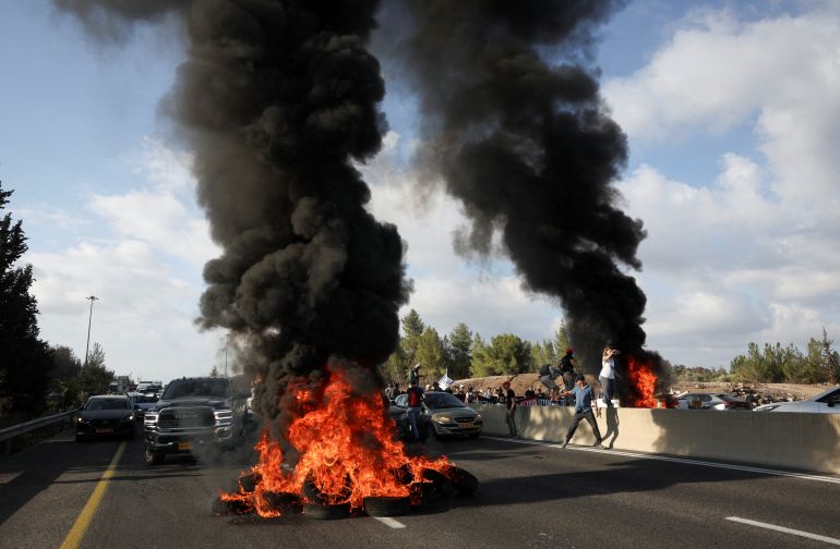 Smoke rises from tyres burnt by demonstrators as people block Israel's main highway connecting Jerusalem and Tel Aviv, after families of hostages have called for a nationwide strike to demand the return of all hostages and an end to the war in Gaza, Latrun Israel August 17,2025 REUTERS/Ronen Zvulun