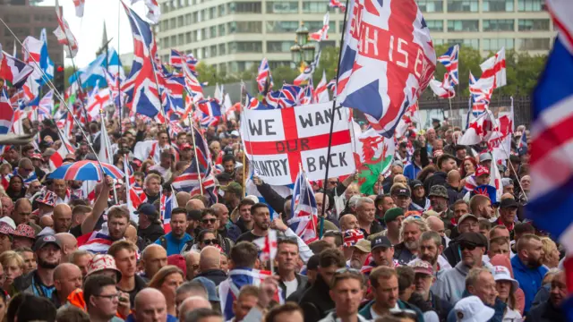 متظاهرون يحملون علم سانت جورج وعلم المملكة المتحدة خلال مظاهرة "توحيد المملكة" في وسط لندن، بريطانيا، 13 سبتمبر/أيلول 2025.