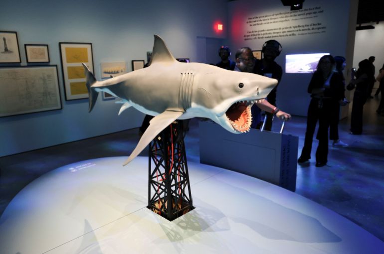 A replica of a shark is displayed as people attend the press preview for "Jaws: The Exhibition" at the Academy Museum of Motion Pictures in Los Angeles, California, U.S., September 10, 2025. REUTERS/Daniel Cole