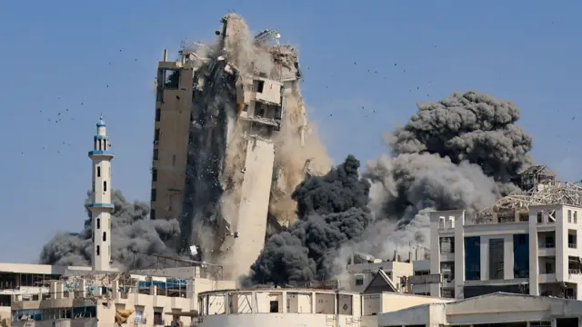 دخان يتصاعد من برج الغفاري السكني، بعد انهياره إثر غارات جوية إسرائيلية في مدينة غزة