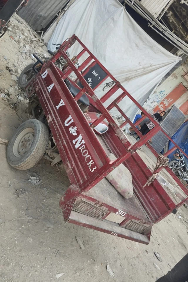 عربة مجرورة صغيرة موصولة بدراجة نارية يستأجرها الغزيون لنقل أغراضهم عند النزوح