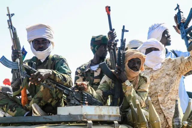 مقاتلون من حركة تحرير السودان يمسكون أسلحة رشاشة 