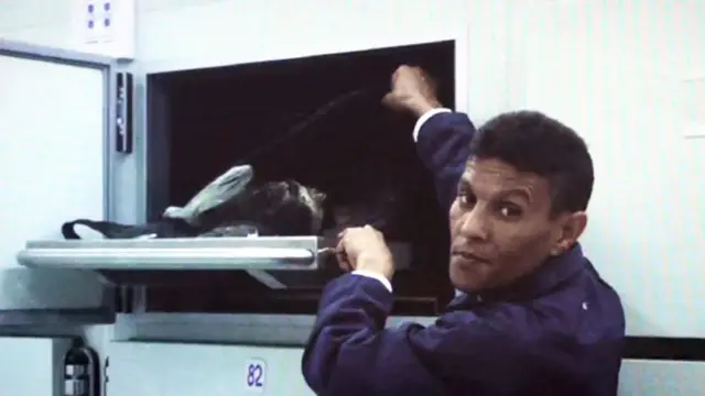 عامل في المشرحة (في الصورة) يظهر الجثة لقاسم حمادة