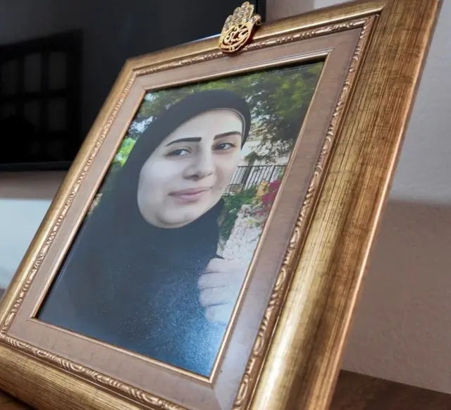 صورة مؤطرة لنايفة على الرف، وهي تنظر نحو الكاميرا.