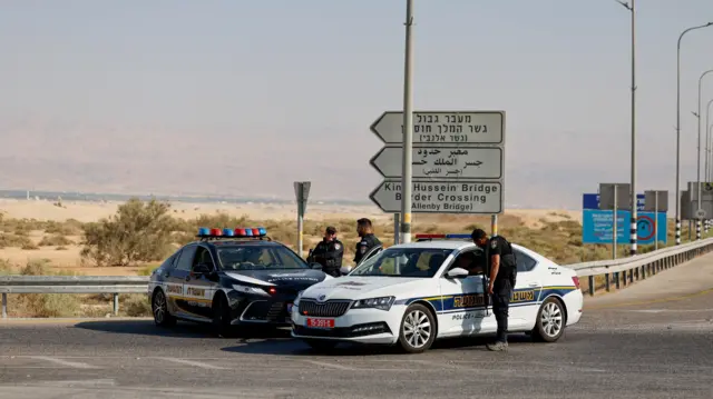 ضباط شرطة إسرائيليون يقفون بجوار سياراتهم في موقع إطلاق نار مميت على معبر اللنبي بين الضفة الغربية المحتلة والأردن