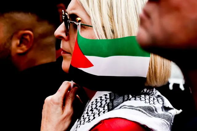 امرأة تحمل علم فلسطين خلال احتجاج بعنوان "لا للأسلحة في مناطق الحرب! السلام بدلًا من سباق التسلح! أوقفوا الإبادة الجماعية في غزة!"، نظمه حزب تحالف ساهرا فاغنكنيخت (BSW) في برلين، ألمانيا، ١٣/أيلول سبتمبر ٢٠٢٥.