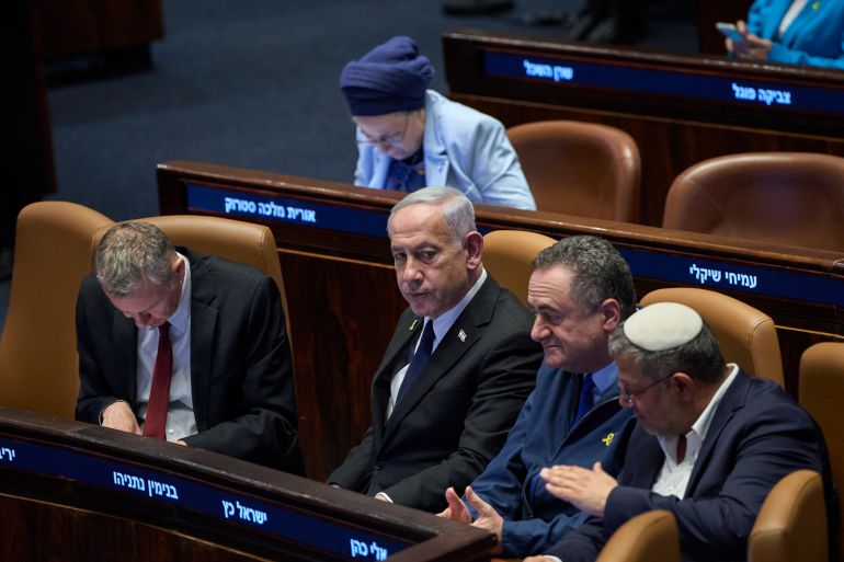 Israel's Prime Minister Benjamin Netanyahu, surrounded by ministers from the government attends a session of the Knesset, Israel's parliament, in Jerusalem, Monday, July 14, 2025. (AP Photo/Ohad Zwigenberg)