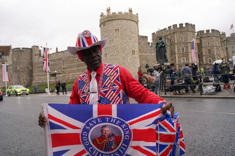 A Royal supporter poses for photos in front of Windsor Castle in Windsor, England, Wednesday, Sept. 17, 2025 ahead of the arrival of President Donald Trump.(AP Photo/Alberto Pezzali)
