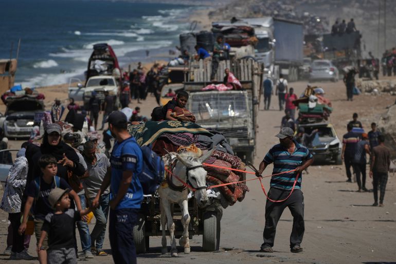 Displaced Palestinians flee Gaza City by foot and vehicles, carrying their belongings along the coastal road toward southern Gaza, Thursday, Sept. 18, 2025. (AP Photo/Abdel Kareem Hana)