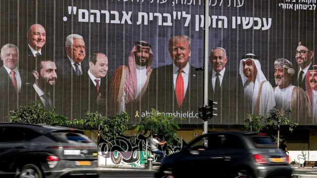 سائقون يمرون أمام لوحة إعلانية في تل أبيب، بتاريخ 26 يونيو/حزيران 2025، عرضتها مبادرة "التحالف من أجل الأمن الإقليمي" السياسية الأمنية الإسرائيلية