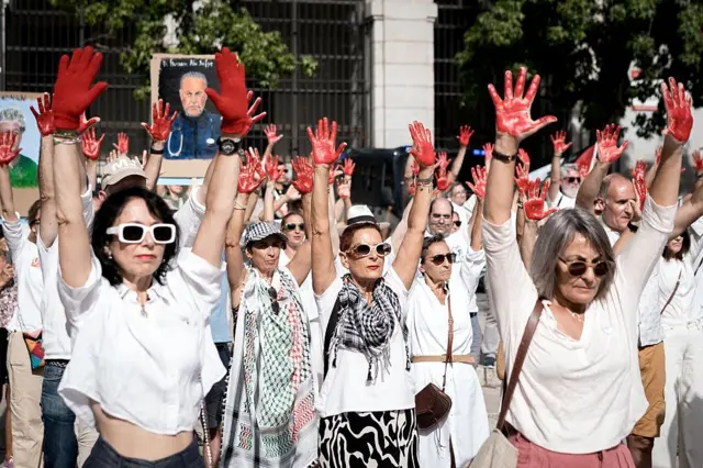 متظاهرون يطلون أيديهم باللون الأحمر تكريماً للعاملين في القطاع الصحي في غزة، أمام متحف الفن المعاصر (ماركو)، في 20 سبتمبر/أيلول 2025 في مدريد، إسبانيا