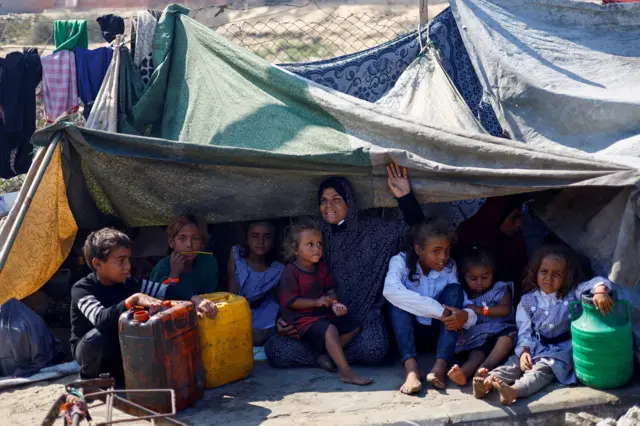 فلسطينيون نازحون فروا من شمال غزة بسبب العملية العسكرية الإسرائيلية، يحتمون على جانب الطريق بعد أن أمرت القوات الإسرائيلية سكان مدينة غزة بالإخلاء إلى الجنوب، في وسط قطاع غزة، 18 سبتمبر/أيلول 2025.