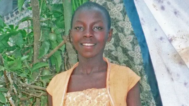 مونيك كارونغي  ترتدي فستانا أصفر وتبتسم للكاميرا