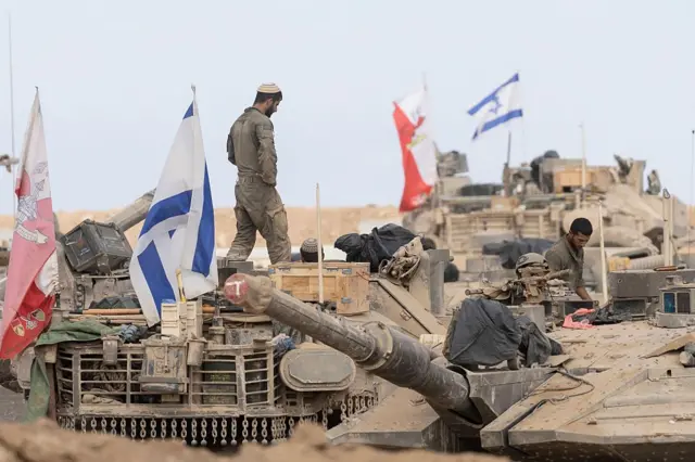جنود إسرائيليون يقفون على دبابات قرب الحدود مع قطاع غزة في 29 أكتوبر/تشرين الأول 2025.