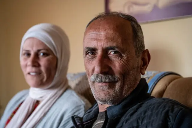 مقبل البرغوثي، شقيق مروان البرغوثي جالسا وتجلس بجانبه سيدة ترتدي غطاء رأس "حجاباً إسلامياً".