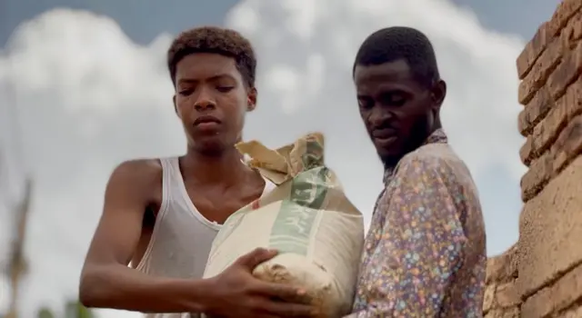 شابان يحاولان استخدام أكياس من الرمال للتصدي لمياه الفيضان