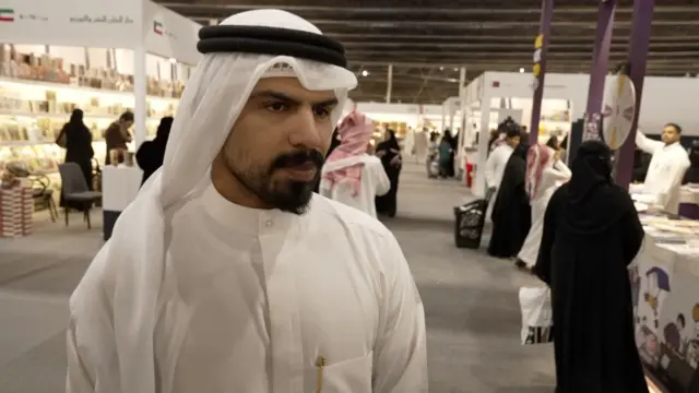 الكاتب الكويتي عبد الله العنزي يرتدي جلباباً أبيض وعقالاً أبيض ويعلو وجهه شارب.