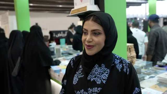 وقعت الكاتبة السعودية نادية الشهري، الجزء الثاني من روايتها "جمنون2 ". وتظهر الكاتبة السعودية نادية الشهري في الصورة مرتديةً عباءة سوداء، بها ورود زرقاء صغيرة، وغطاء رأس أسود وتظهر أجزاء من شعرها أعلى جبهتها.