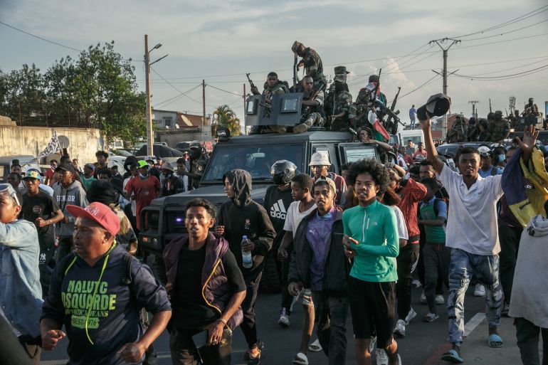 Members of a Madagascar army contingent of the CAPSAT regiment who left the camp to reach the 13 Mai plaza interact with protesters in Antananarivo on October 11, 2025.