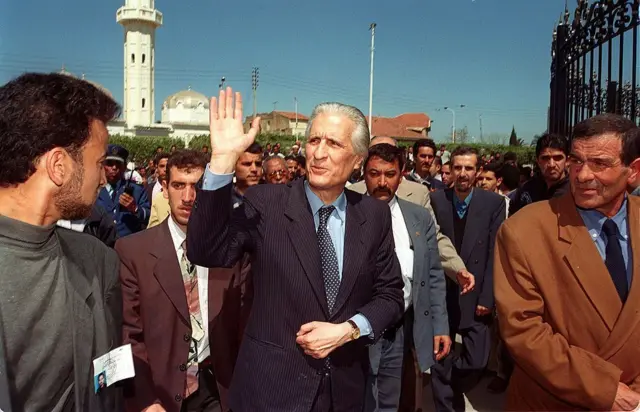 وزير الخارجية الجزائري الأسبق والمرشح للرئاسة أحمد طالب الإبراهيمي يلوّح لمناصريه في 6 أبريل/نيسان 1999 في مدينة البليدة، خلال حملته الانتخابية للانتخابات الرئاسية.